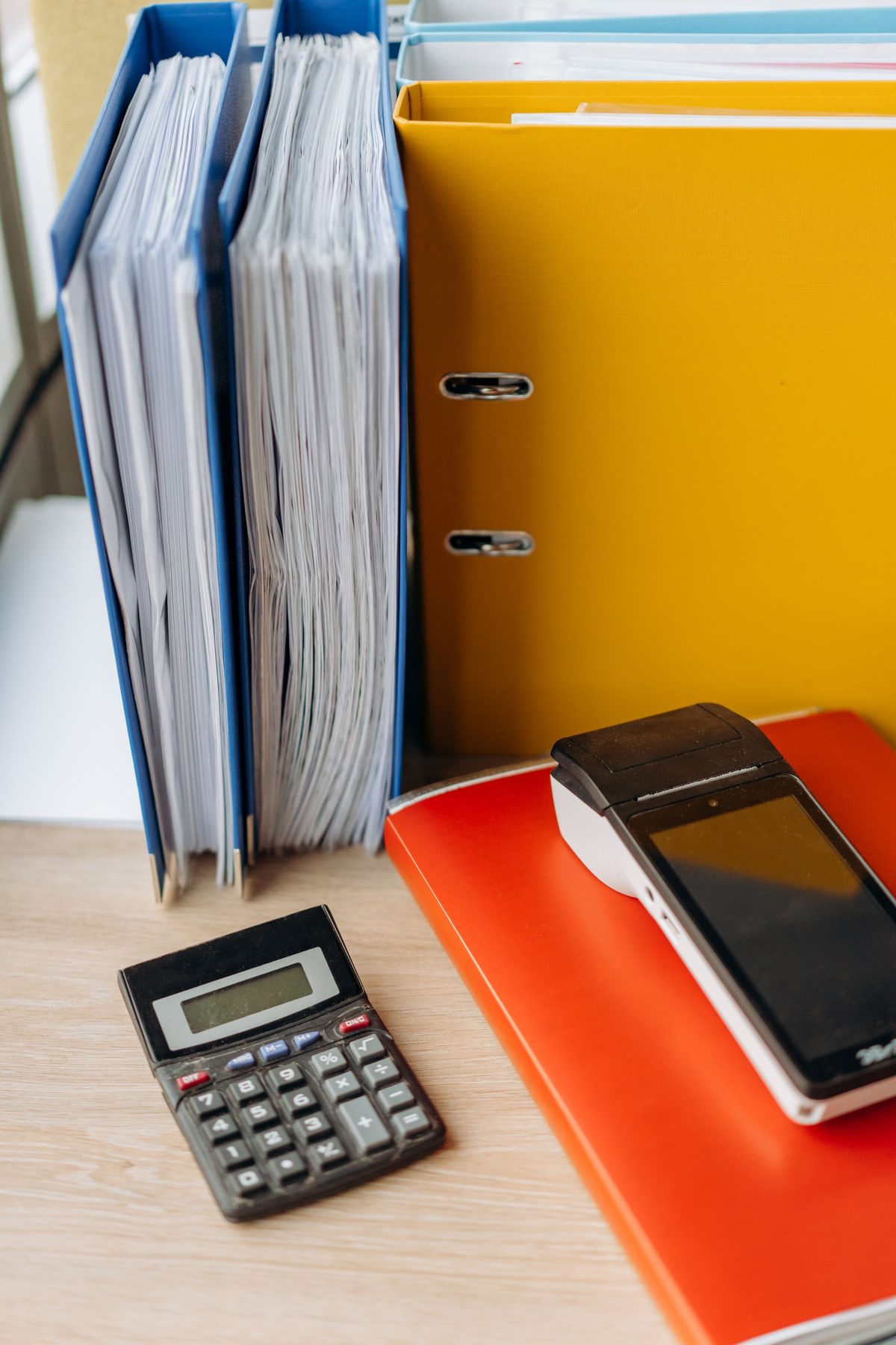 Binders, files and a calculator on a desk